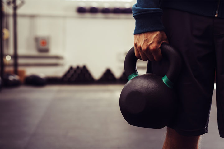 Close-up of man holding heavy kettlebell